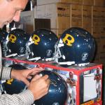 Joe Montana autographs his high school helmets for National Sports Distributors