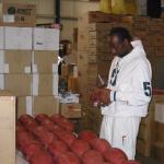 Jerry Rice autographing footballs for National Sports Distributors