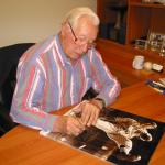 Bob Feller autographing photos for National Sports Distributors