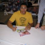 Tony Gonzalez autographing 8x10 photos for NSD