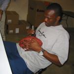 Issac Bruce autographing footballs for National Sports Distributors
