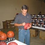 Trent Green autographing footballs for National Sports Distributors