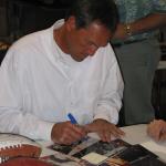 Dwight Clark signing photos of his famous "Catch" at National Sports Distributors