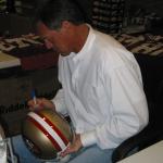 Dwight Clark autographing helmets for National Sports Distributors