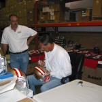 Dwight Clark autographing helmets at  National Sports Distributors