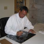 Dwight Clark autographing photos for National Sports Distributors