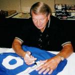 Johnny Unitas autogaphing jerseys for National Sports Distributors