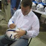 Peyton Manning autographing helmets for National Sports Distributors