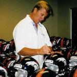 John Elway autographing helmets for National Sports Distributors