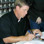 Troy Aikman autographing cards for National Sports Distributors