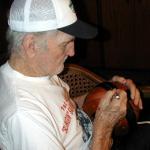 Sammy Baugh autographing footballs for National Sports Distributors