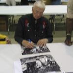 Chuck Bednarik autographing photos for National Sports Distributors