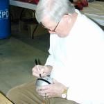 George Blanda autographing mini helmets for National Sports Distributors