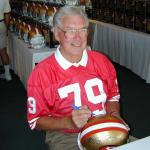 Bob St Claire autographing helmets for National Sports Distributors