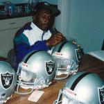 Tim Brown autographing helmets for National Sports