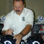 Dick Butkus autographing helmets for National Sports Distributors