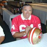 Dave Wilcox autographing helmets for National Sports Distributors