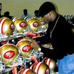 Deion Sanders autographing helmets for National Sports Distributors