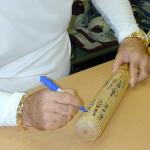 Pete Rose autographing some unique bats for National Sports Distributors