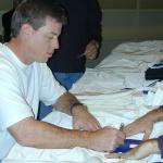 Troy Aikman autographs his Dallas Cowboys jerseys for National Sports Distributors