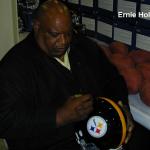 Ernie Holmes of the Steel Curtain autographing helmet for National Sports Distributors