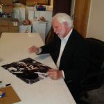 Ken Stabler autographing photos for National Sports Distributors