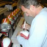 Joe Montana autographing footballs for National Sports Distributors