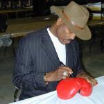 George Frazier autographing boxing gloves for National Sports Distributors