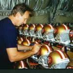 Joe Montana autographing helmets for National Sports Distributors