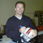 Howie Long autographing helmets for National Sports Distributors