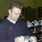 Howie Long autographing helmets for National Sports Distributors