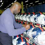 Lawrence Taylor autographing helmets for National Sports Distributors