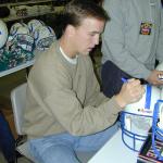 Peyton Manning autographing helmets for National Sports Distributors