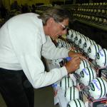 Joe Namath autographing mini helmets for National Sports Distributors