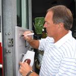 Dwight Clark autographing a fire truck at National Sports Distributors