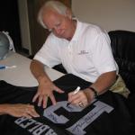 Ken Stabler autographing Raider jerseys for National Sports Distributors