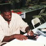 Larry Johnson autographs photos for National Sports Distributors