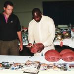 Emmitt Smith autographs footballs for National Sports Distributors