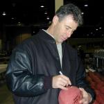 Rich Gannon autographing footballs for National Sports Distributors