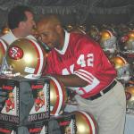 Ronnie Lott autographing helmets for National Sports Distributors