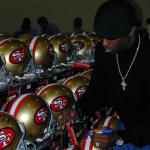 Deion Sanders autographing helmets for National Sports Distributors