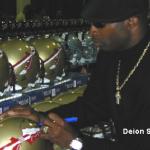 Deion Sanders autographing helmets for National Sports Distributors