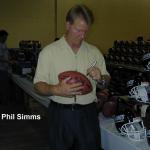 Phil Sims autographing footballs for National Sports Distributors