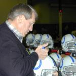 Johnny Unitas autographing helmets for National Sports Distributors